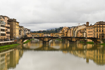 Cityscape from the Arno River with the Ponte Santa Trinita and the Ponte Vecchio in the background on a cloudy spring day, Florence, Tuscany, Italy