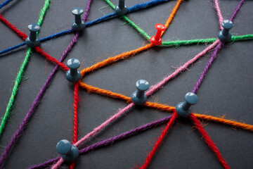The concept of social networks and communication in society. The pins are connected with colored...