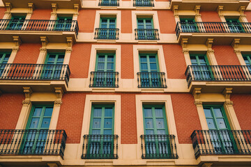 Fototapeta premium A beautiful apartment building in Europe with balconies and vibrant green windows, featuring symmetrical design.