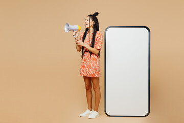 Full body young Latin woman she wear orange dress casual clothes big huge blank screen mobile cell...