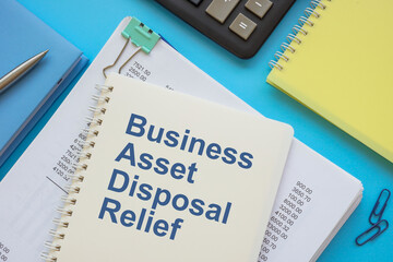 Stack of financial papers and book business asset disposal relief.