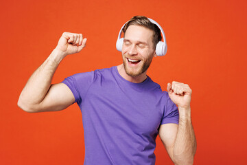 Young smiling cheerful cool happy man he wear purple t-shirt casual clothes listen to music in...
