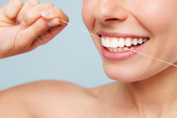 Close up cropped half naked topless young woman use floss for brushing sensitive white teeth...