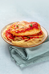Chicken Parmesan, Italian pasta dish. Breaded chicken breast with cheese and spaghetti with tomato sauce, a delicious plate
