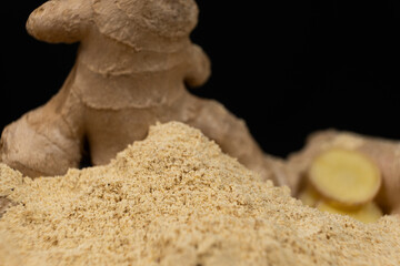 Ground ginger as a fine dry powder, macro on a black background