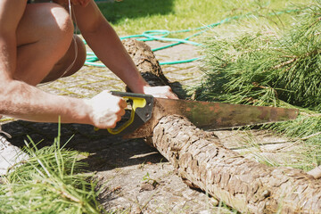 Cropped shot of mans hands sawing wood