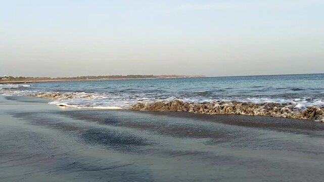 Beautiful beach with waves of blue calm water coming near and moving back with background clea sky, Full HD