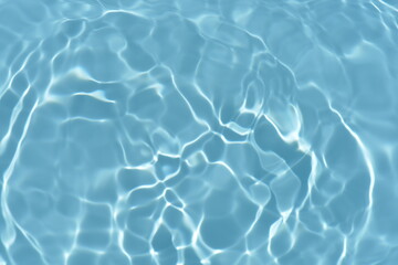 Blue water with ripples on the surface. Defocus blurred transparent blue colored clear calm water surface texture with splashes and bubbles. Water waves with shining pattern texture background.