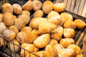 An image showcasing a variety of freshly baked bread loaves with a golden crust, housed in a dark basket