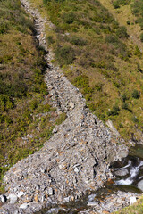 Scenic close-up view of Foss River with debris at Swiss mountain pass Gotthard on a sunny late summer day. Photo taken September 10th, 2023, Gotthard, Switzerland.