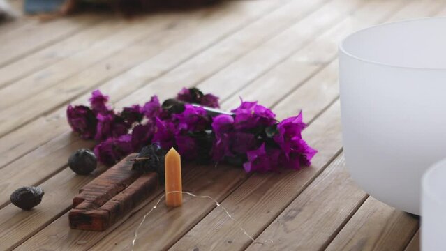 Sound therapy elements on wooden surface: Singing bowl and flowers
