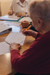 Old woman close up hand hold pen sign contract put signature.A woman signs a will