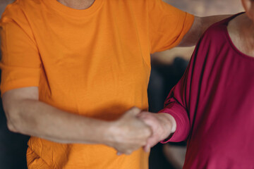 Woman volunteer helping elderly woman walk with walker at home.Walking movement disability impairment