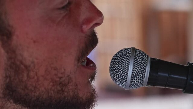 Man vocalizing closely into a microphone for sound therapy