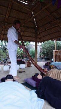 Man playing a large wooden instrument for sound therapy