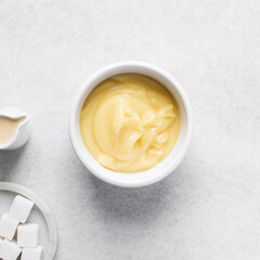 Overhead view of nigerian akamu in a white bowl, pap akamu or ogi in a white bowl, top view of nigerian corn pudding in a white ramekin