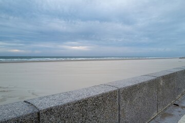 wall in front of the empty beach and sea in the evening