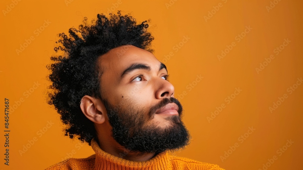 Poster portrait of a thoughtful contemplative multi ethnic man with a calm assured expression posing agains