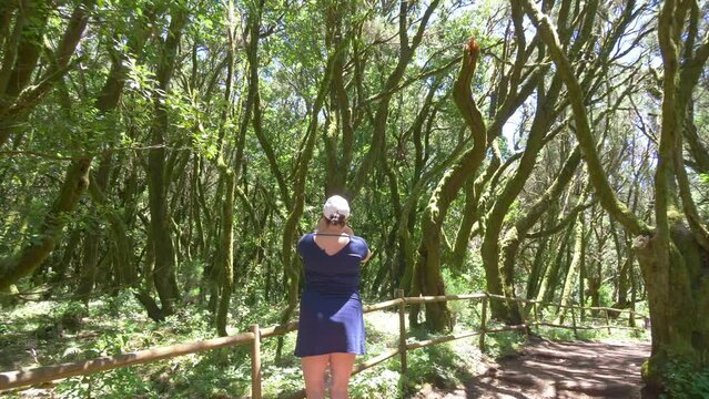 Woman takes piture of ancient laurel forest in Gomera island in 4k slow motion 60fps