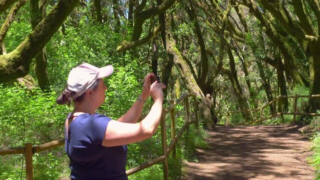 Woman takes piture of ancient laurel forest in Gomera island in 4k slow motion 60fps