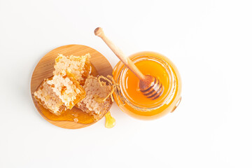 Honey dripping from a wooden honey dipper on white background. Healthy organic food concept. 