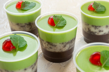 puding lapis alpukat or avocado layer pudding. topped with cherry pieces and mint leaves. Very fresh and healthy