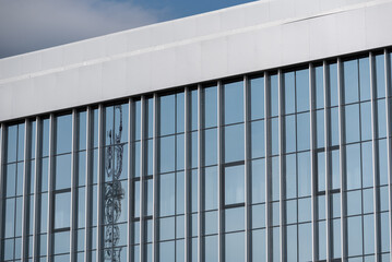 empty glass windows of a modern building with a reflection of the sky in the glass