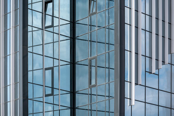 Fototapeta premium empty glass windows of a modern building with a reflection of the sky in the glass