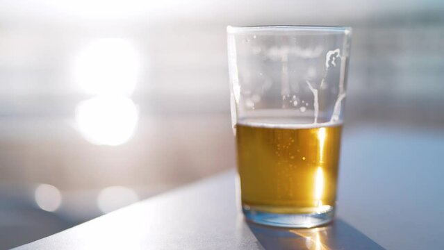 Beer half empty or half full with people passing in blurry background