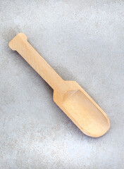 Small wooden scoop on grey surface with copy space