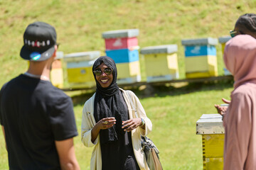 A diverse group of young friends and entrepreneurs explore small honey production businesses in the natural setting of the countryside.