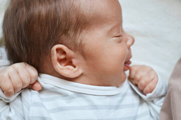 Infant resting peacefully baby looking angelic while lying alone and sleeping in his soft...