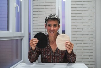 smiling woman looking at camera showing cancer equipment