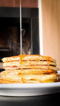 Close up of pouring mapple syrup on buttermilk pancakes