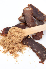 Flat lay of powdered biltong with sliced biltong on the side with copy space isolated on white