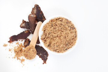Flat lay of powdered biltong with sliced biltong on the side with copy space isolated on white