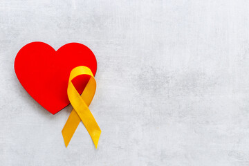 Yellow ribbon with heart for world bone cancer day
