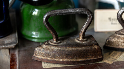 Vintage iron on a wooden table with retro items evokes a nostalgic feel of the past