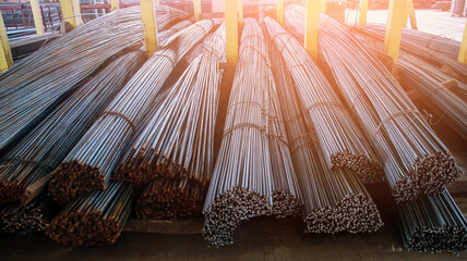 Neatly Stacked Steel Rebar Bundles at a Busy Construction Site on a Sunny Day