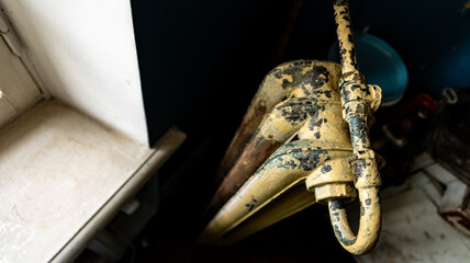 An old, rusty water pump in an abandoned building, showing signs of decay and neglect