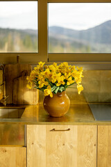 Yellow tulips in vase on a kitchen table top
