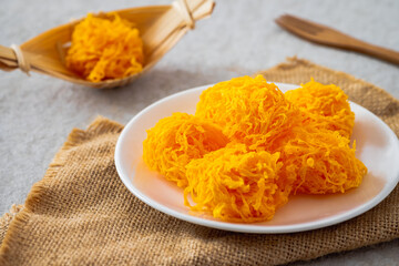 Crispy golden egg yolk threads on white plate, Thai dessert