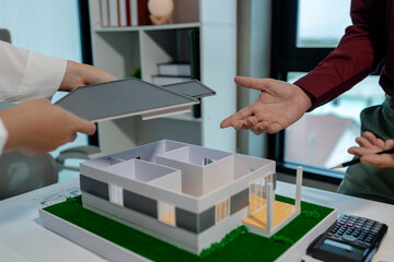 two architects are discussing about new project of the biggest housing estate company who hire...