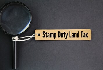 magnifying glass and a paper tag with the word Stamp Duty Land Tax or the letter SDLT