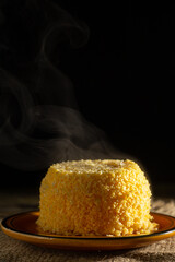 Dish of couscous "cuscuz brasil" "Cuscus,Cuzcuz,Cuscuz" individual portion, mini traditionally from the north and northeast of Brazil, typical food of Brazilian cuisine, on a rustic wooden table