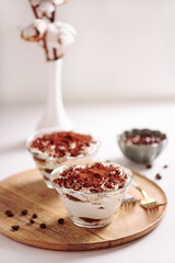 Traditional Italian dessert tiramisu in glasses on white table. Soft focus