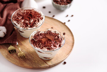 Traditional Italian dessert tiramisu in glasses on white table. Soft focus