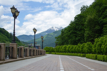 Rosa Khutor embankment, mountains and green forest. Krasnaya Polyana, Sochi.