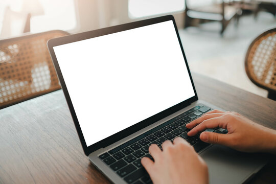 Close-up image of a man sitting in the cafe and using her laptop.  laptop white blank screen mockup for display your graphic banner.