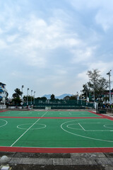 The scene of outdoor basketball court with seascape and skyscape. Outdoor sports and recreation court. Nobody in the basketball court in the sunny day. Sports and recreation concept.